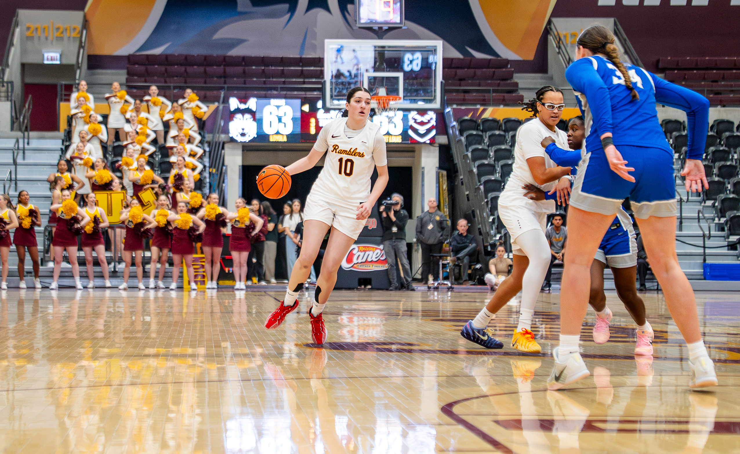 Loyola Chicago freshman guard/forward Alex-Anne Bessette dribbles the ball in her right hand while she looks down the court.