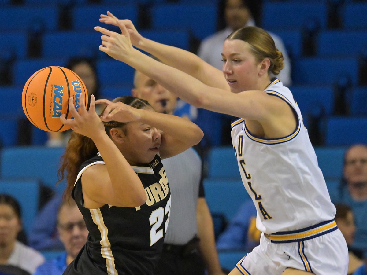 UCLA’s Amanda Muse smothers Purdue’s Kiki Smith defensively while the Bruins’ home crowd looks on.