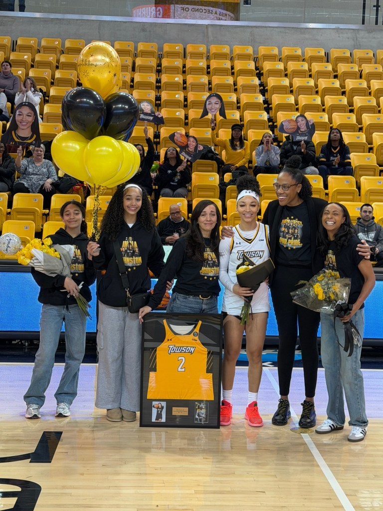 Towson's India Johnston is celebrated during senior day wearing a white shirt with her family.
