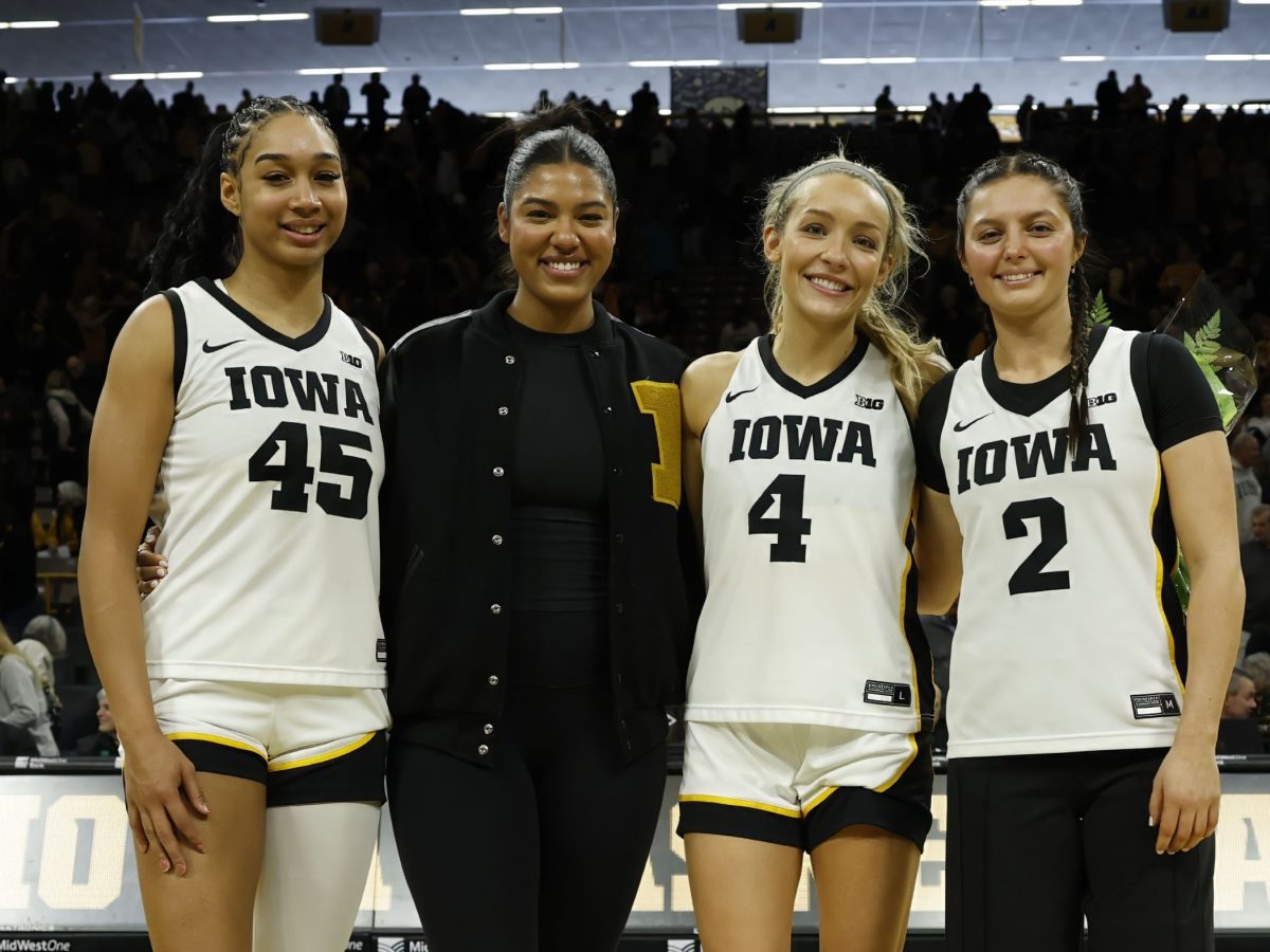 Iowa seniors Hannah Stuelke, Jada Gyamfi, Kylie Feuerbach and Taylor McCabe stand with their arms around each other at mid-court.