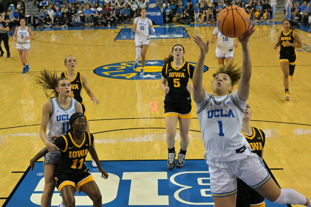 Kiki Rice drives toward the basket and attempts a shot.