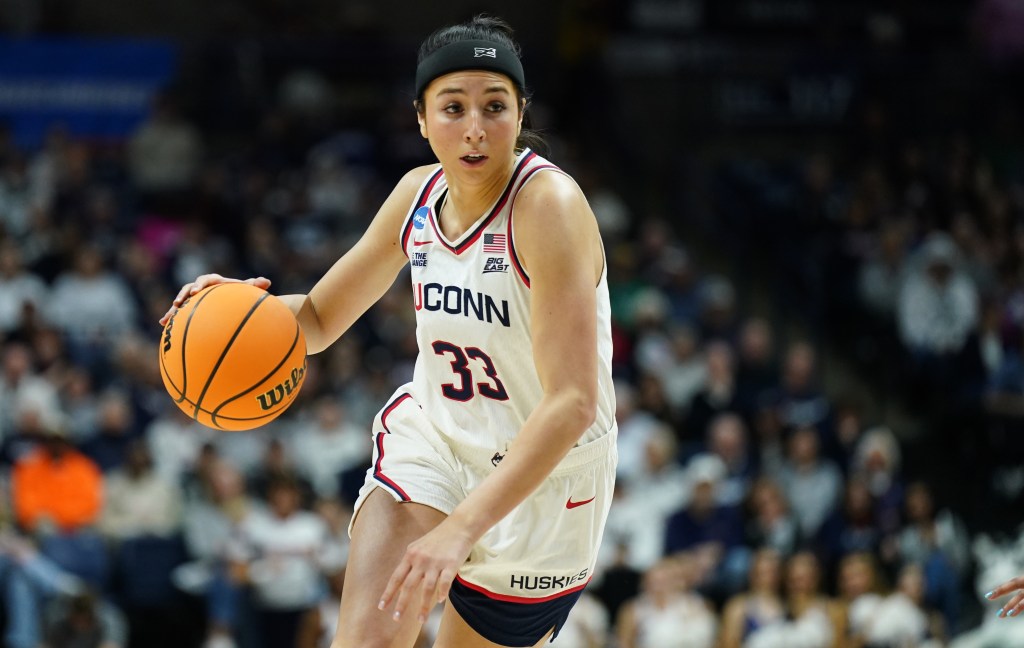 UConn guard Caroline Ducharme dribbles the ball with her right hand.