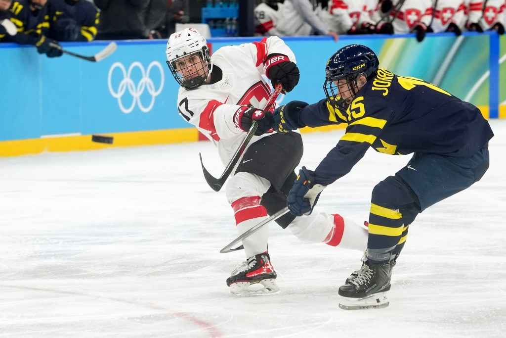 Lara Christen on the left fires a shot on goal around Sweden's Lisa Johansson who's on the right.