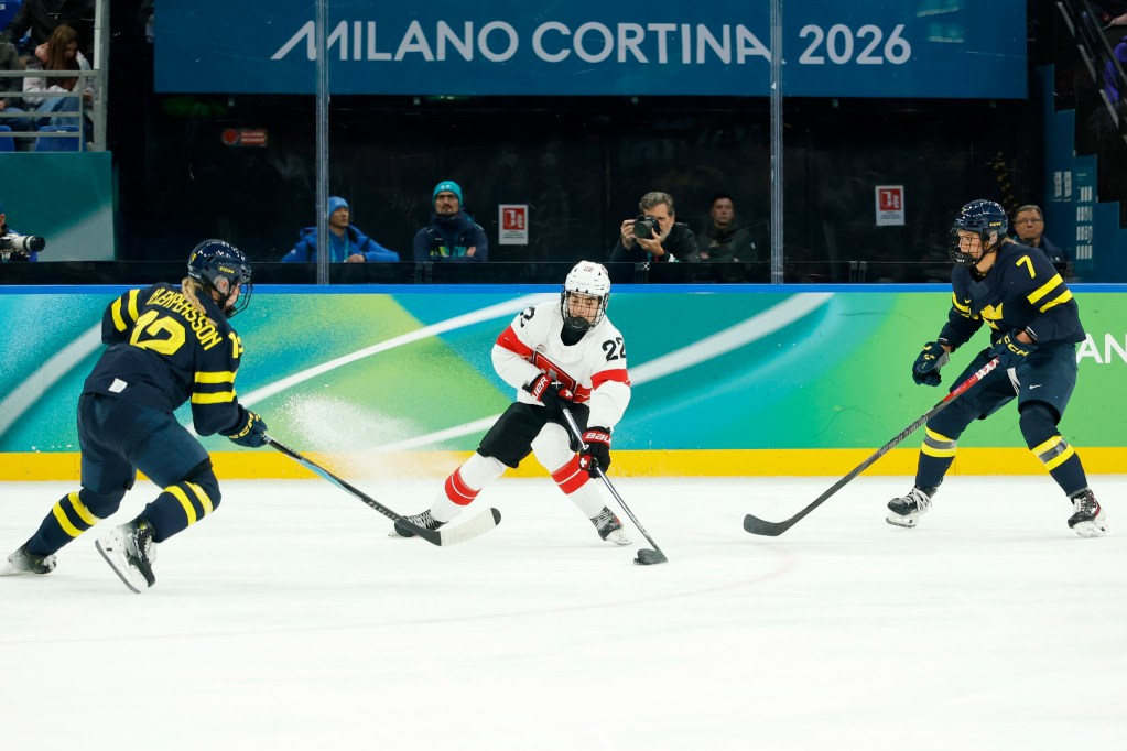 Sinja Leemann of Switzerland controls the puck against Sweden defenders