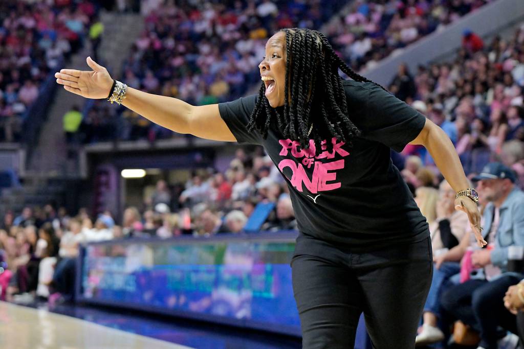 Ole Miss head coach Yolett McPhee-McCuin has her open hand pointed toward the court and is yelling.