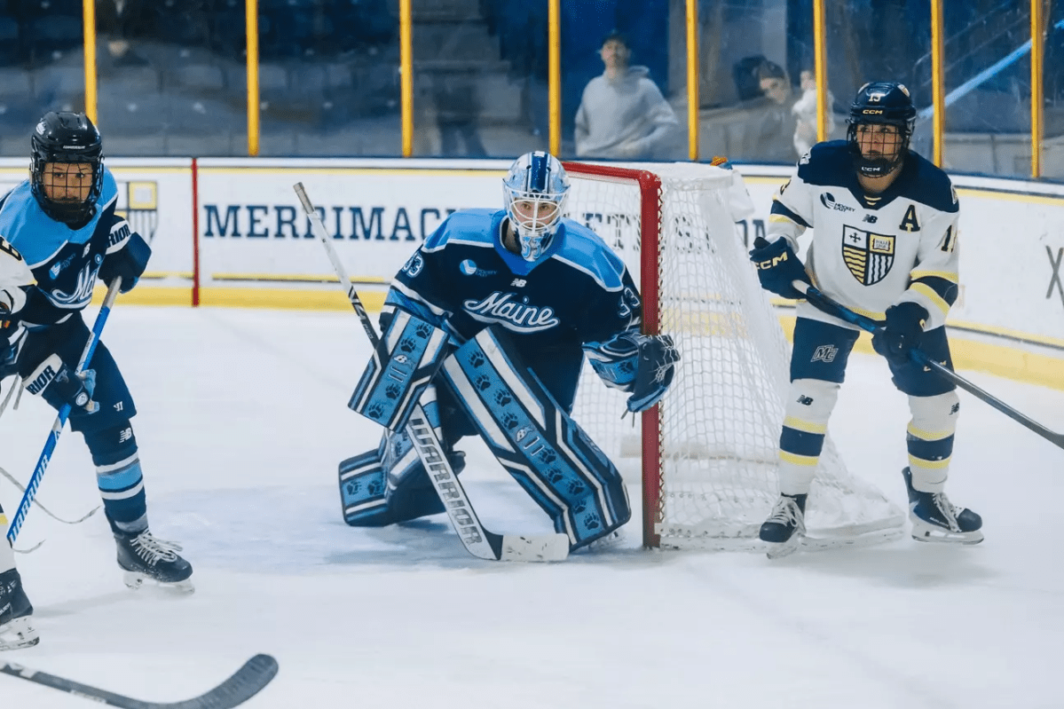 Kiia Lahtinen defends the net. There is a Merrimack player to her left.