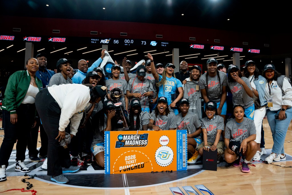 A team is celebrating a championship with the NCAA ticket in the front.