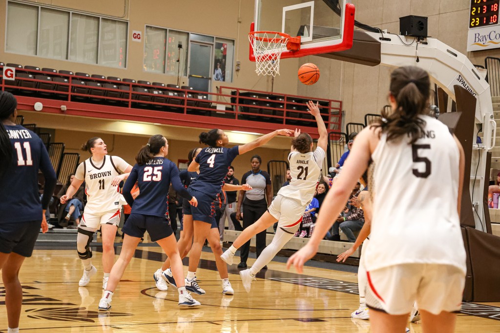 Brown guard Grace Arnolie leans to her right in midair, creating space for her to get around a defender and shoot a right-handed layup.