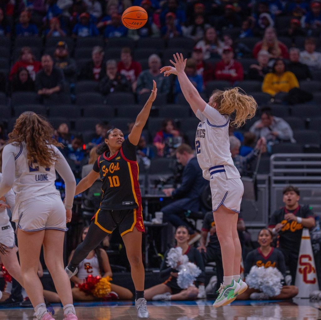 Washington guard Avery Howell shoots a three-point shot over a USC defender trying to close out with her hand up in a Big Ten Tournament game on March 5, 2026, at Gainbridge Fieldhouse in Indianapolis, Ind.