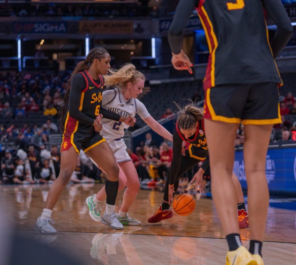 Washington guard Avery Howell works to dispossess USC in a Big Ten Tournament game on March 5, 2026, at Gainbridge Fieldhouse in Indianapolis, Ind. One offensive player is on Howell's hip and the other, in front of her, is struggling to pick up the ball as Howell reaches in.