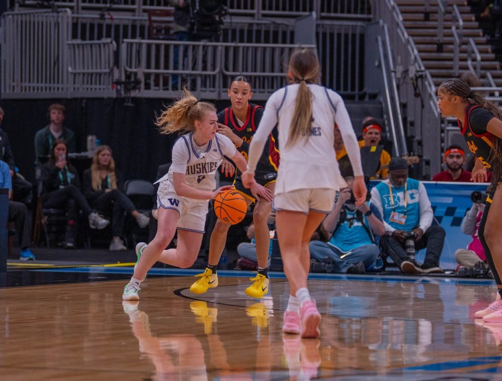 Washington guard Avery Howell drives with the ball against USC, with a defender on her hip and another a few feet in front of her, in a Big Ten Tournament game on March 5, 2026, at Gainbridge Fieldhouse in Indianapolis, Ind.