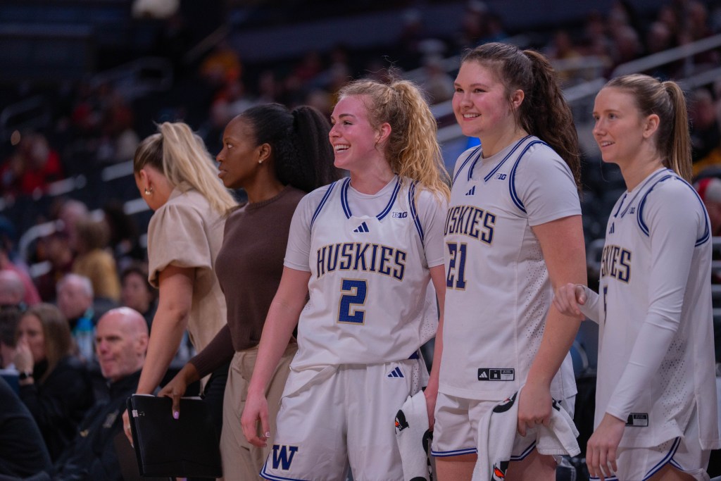 Washington guard Avery Howell and center/forward Brynn McGaughy smile together on the bench during a Big Ten Tournament game against USC on March 5, 2026, at Gainbridge Fieldhouse in Indianapolis, Ind.
