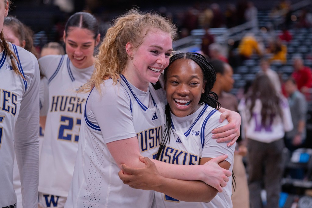 Washington guards Avery Howell and Sayvia Sellers walk off the court embracing with massive grins on their faces after defeating USC in a Big Ten Tournament game against on March 5, 2026, at Gainbridge Fieldhouse in Indianapolis, Ind.