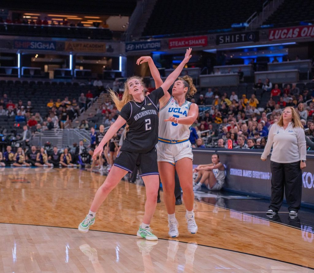 Washington guard Avery Howell defends against UCLA guard Charlisse Leger-Walker in a Big Ten Tournament game on March 6, 2026, at Gainbridge Fieldhouse in Indianapolis, Ind. Leger-Walker has released a three-point shot but Howell still has her hand in her face.