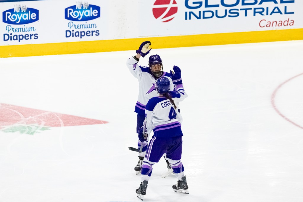 Heise and Cooper high-five. They are wearing white away uniforms.