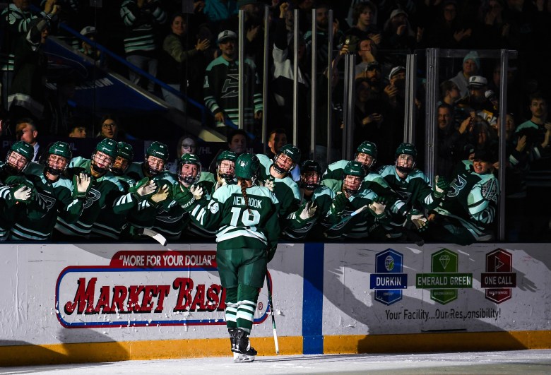 Newhook skates down the handshake line at the bench. She is wearing a green home uniform.
