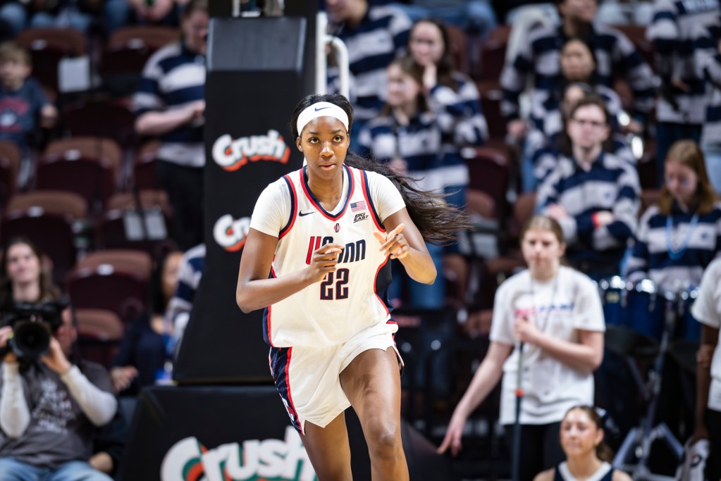 Serah Williams points with both hands while running the court