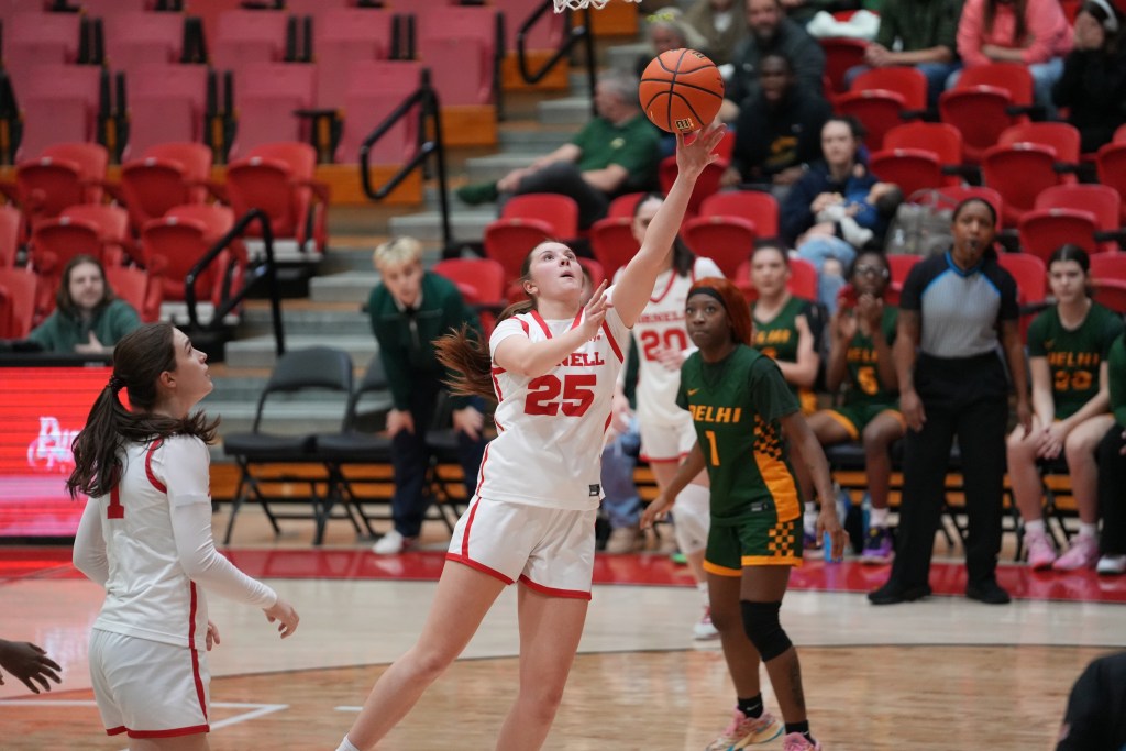 Cornell guard/forward Ally Pape shoots a left-handed layup. She looks up at the rim as she shoots, and no defender is around to contest it. Players in the background watch as the shot goes up.