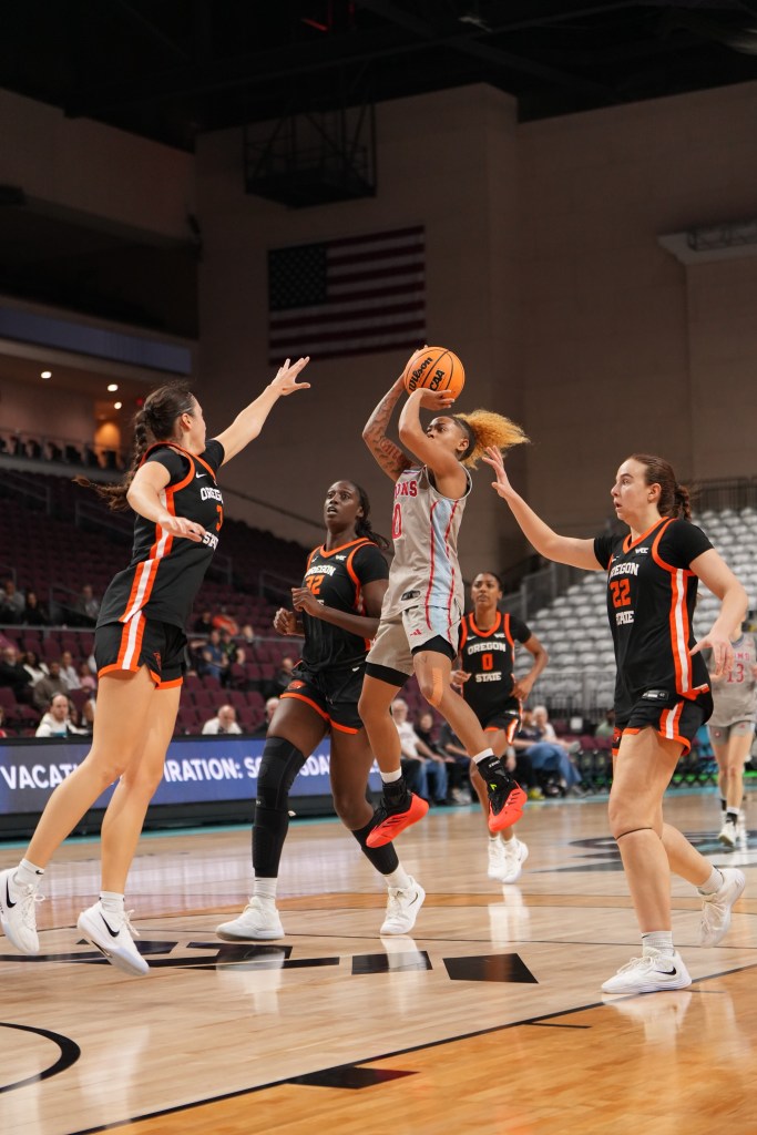 LMU guard Jess Lawson shoots a pull-up jump shot. She is in mid-air with the ball still in her hands. She is surrounded by three Oregon State defenders.