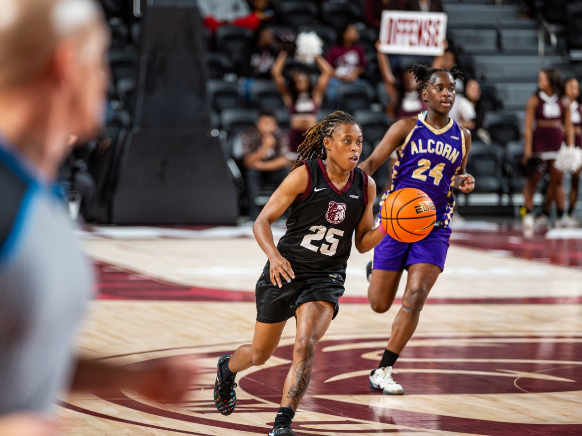Kaila Walker has the ball and is dribbling in front of an Alcorn State defender