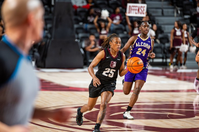 Kaila Walker has the ball and is dribbling in front of an Alcorn State defender