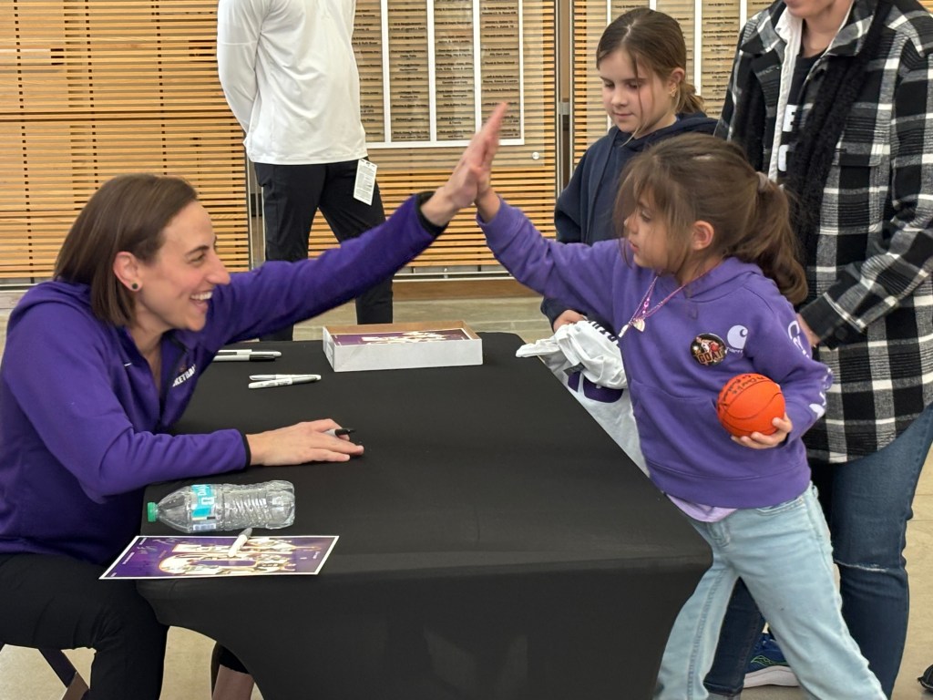 Jacqui Kalin high-fives a young fan during after signing an autograph on Feb. 28, 2026 when the University of Northern Iowa women's basketball retired Kalin's #10 jersey at the McCloud Center in Cedar Falls, Iowa.