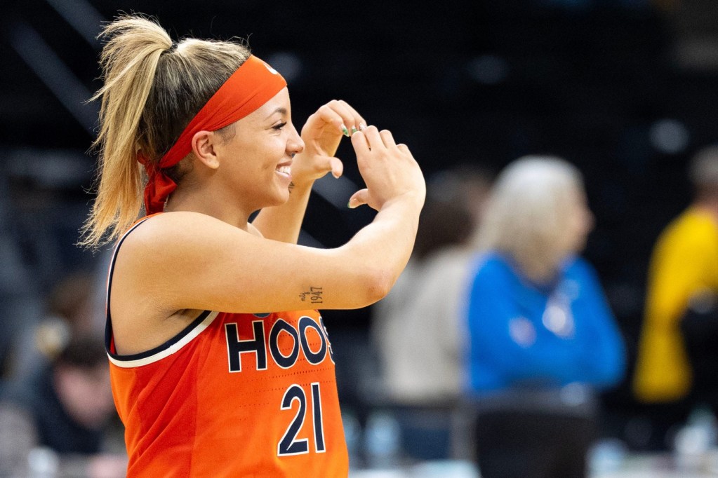 Virginia guard Kymora Johnson shows a heart with her hands to Cavalier supporters.
