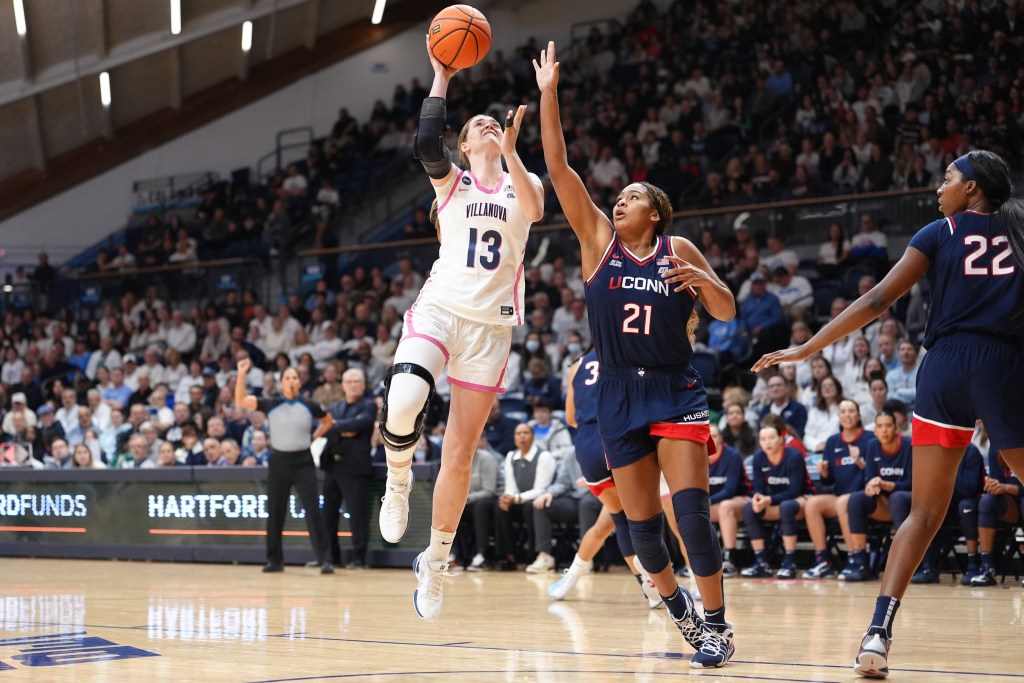 Brynn McCurry drives to the basket with a left-handed shot against the outstretched hand of defender Sarah Strong