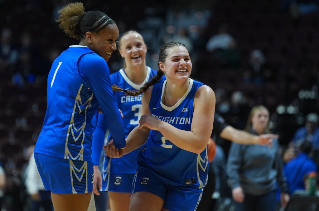 Kennedy Townsend smiles and celebrates with two teammates