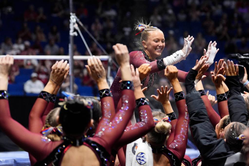 A group of Oklahoma gymnasts celebrate in crimson and black leotards