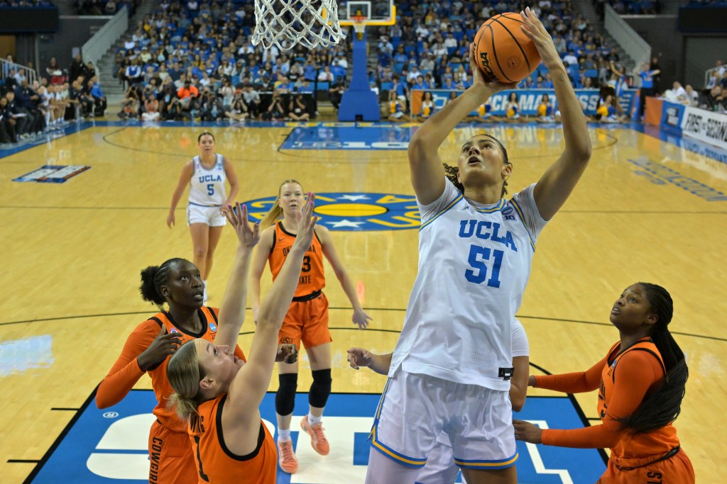 Lauren Betts shoots a lay-up over a group of Oklahoma State defenders