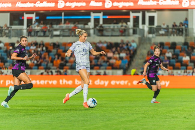 Racing Louisville's Lauren Milliet kicks the ball down the field