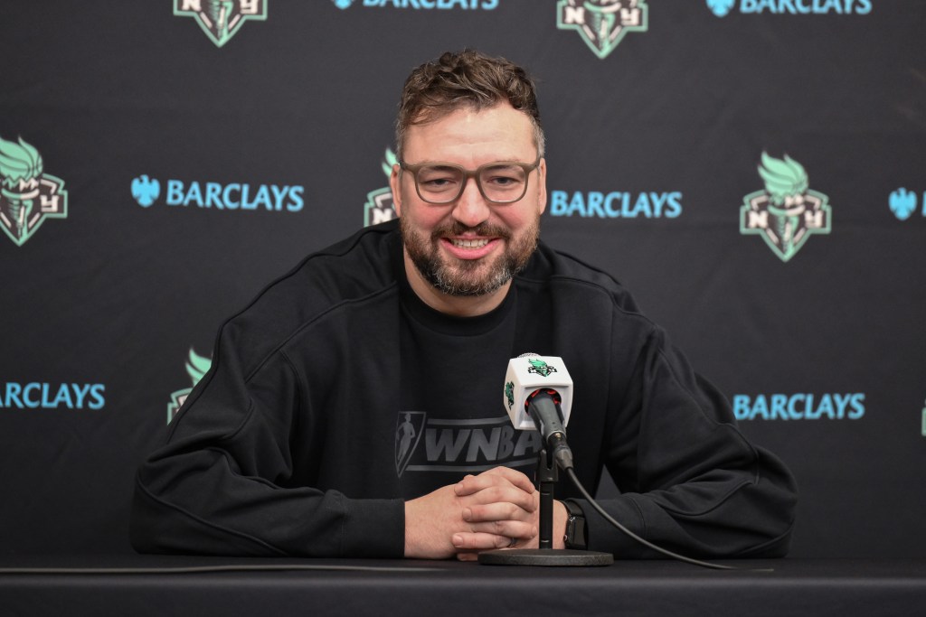 New York Liberty head coach Chris DeMarco smiles while sitting for his first pregame press conference.
