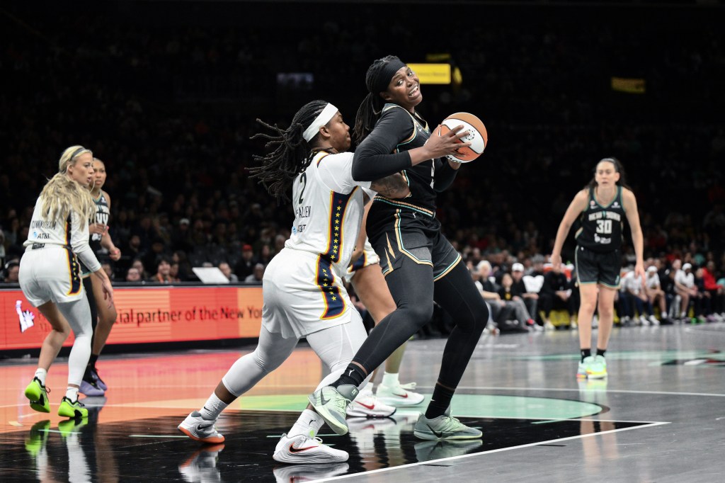 New York Liberty center Jonquel Jones holds the ball with both hands and posts up Indiana Fever forward Myisha Hines-Allen.