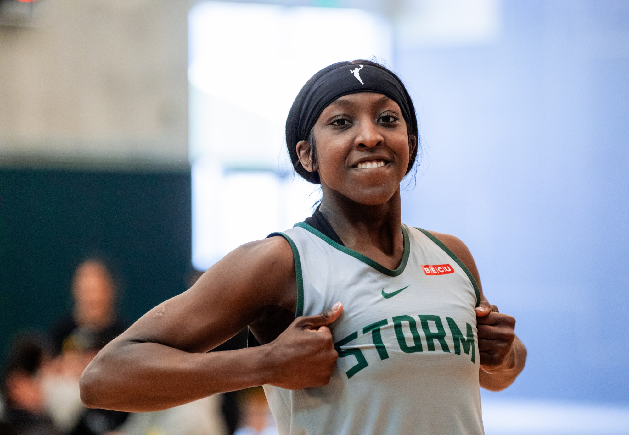 Flau'jae Johnson grins and mimics ripping open a shirt to reveal and highlight the Storm logo across her chest.