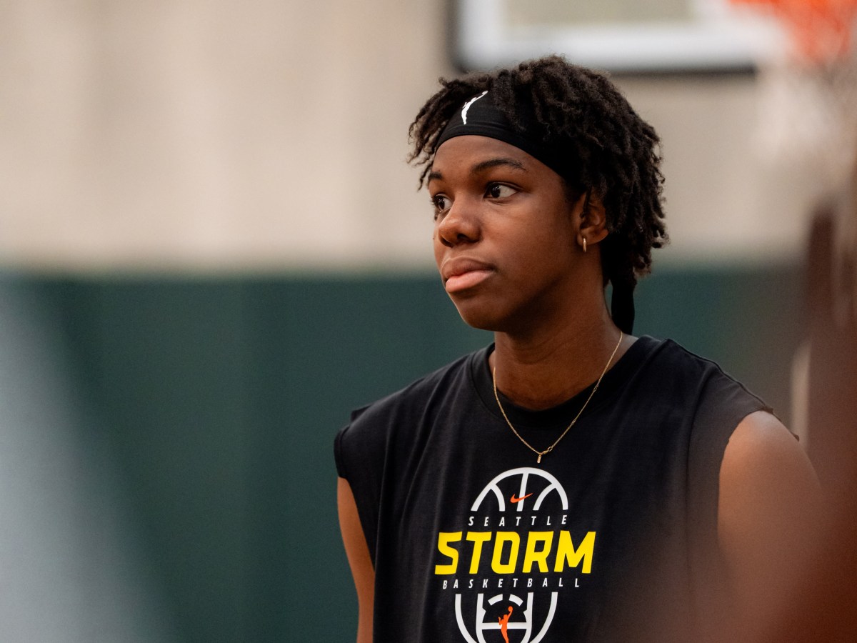 Dominique Malonga looks into the distance. She is wearing her short hair with a black WNBA headband and a black Seattle Storm basketball tank top.