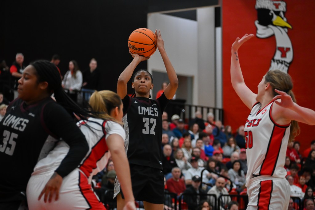 Kaliya Perry prepares to shoot the ball as its raised above her head as a pair of Youngstown State defenders close in.