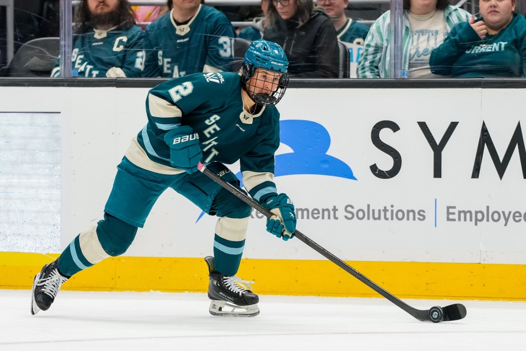 Tejralová looks ahead as she skates with the puck. She is wearing a teal home uniform.