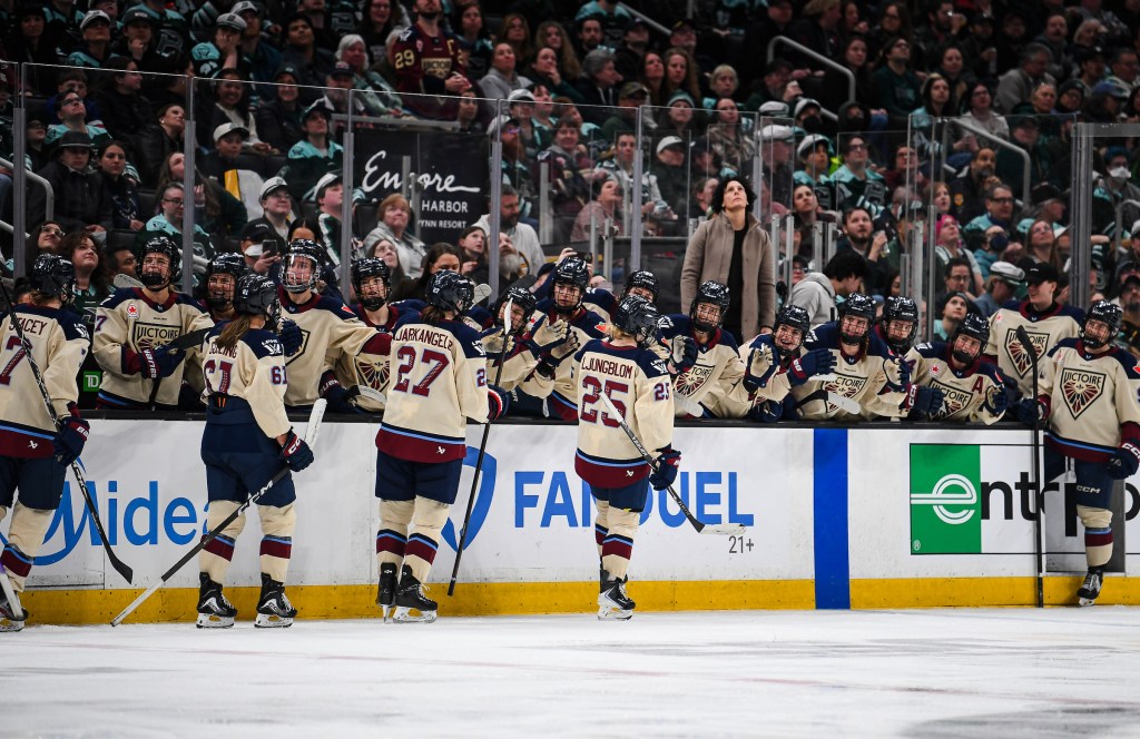 Ljungblom leads her teammates down the handshake line at the bench. They are wearing cream away uniforms.