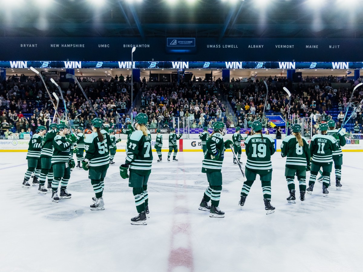 The Fleet stand around the center ice circle, sticks raised in salute. They are wearing green home uniforms.