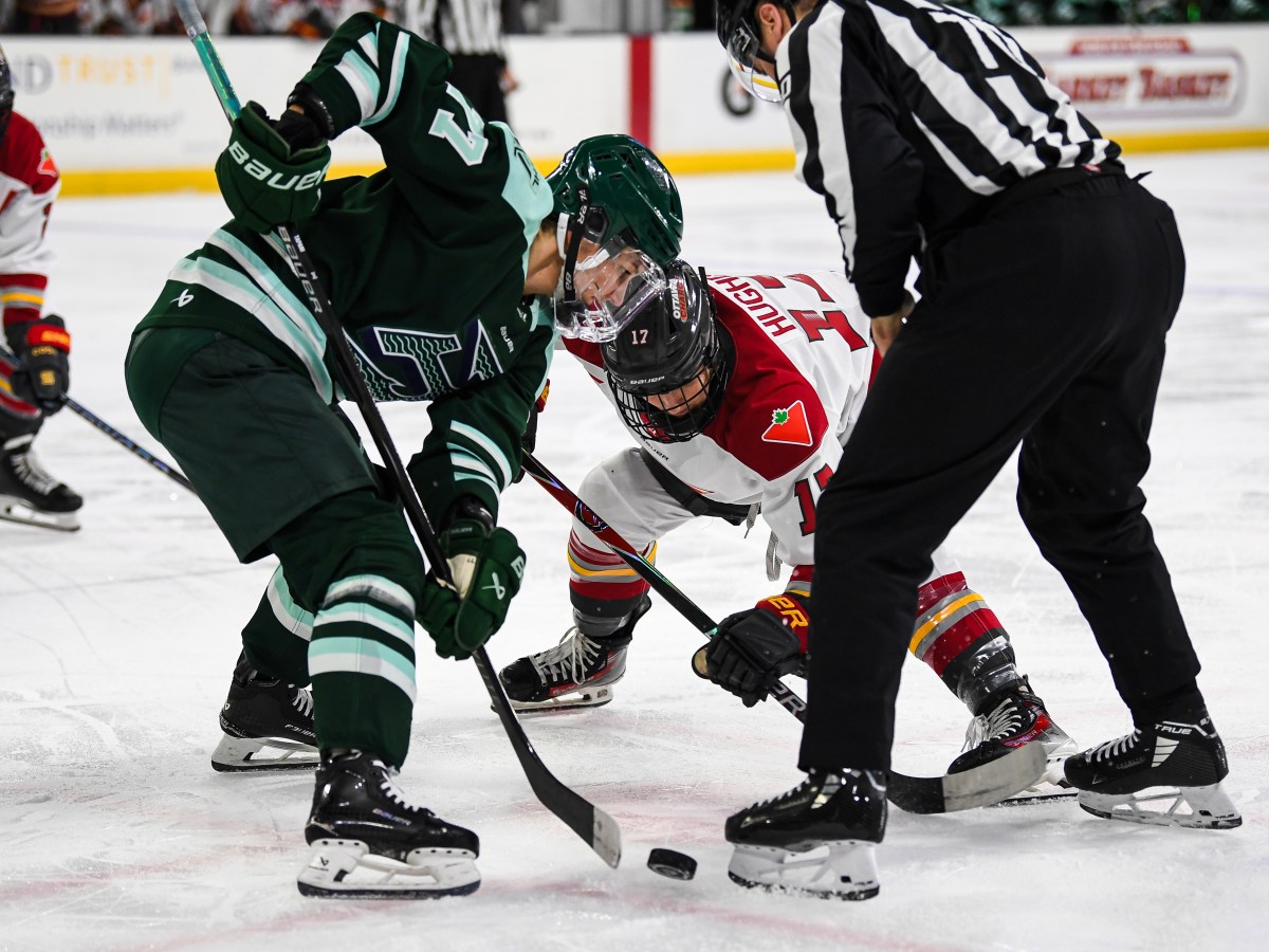 Tapani and Hughes put their sticks down for a faceoff. Tapani is wearing a green home uniform, while Hughes is in a white away one.