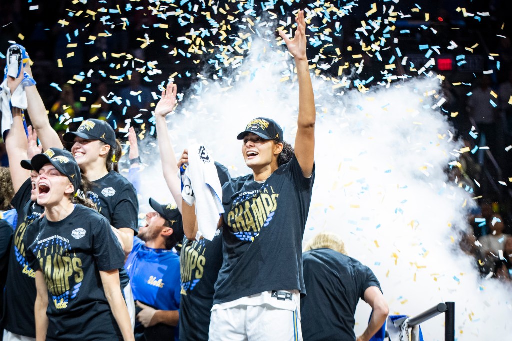 Lauren Betts raises her arm in triumph.