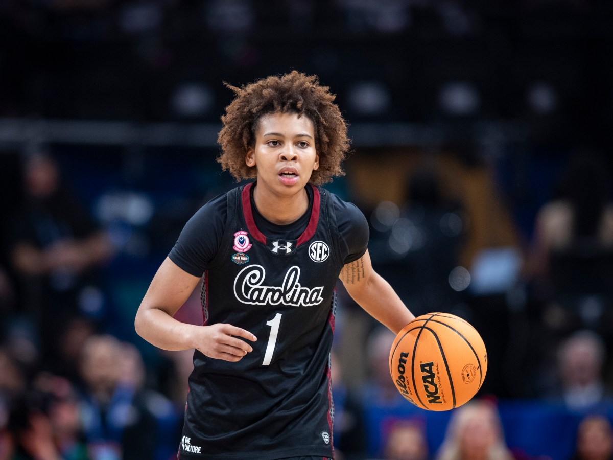 Maddy McDaniel is dribbling with the ball in her left hand and her mouth slighty open.