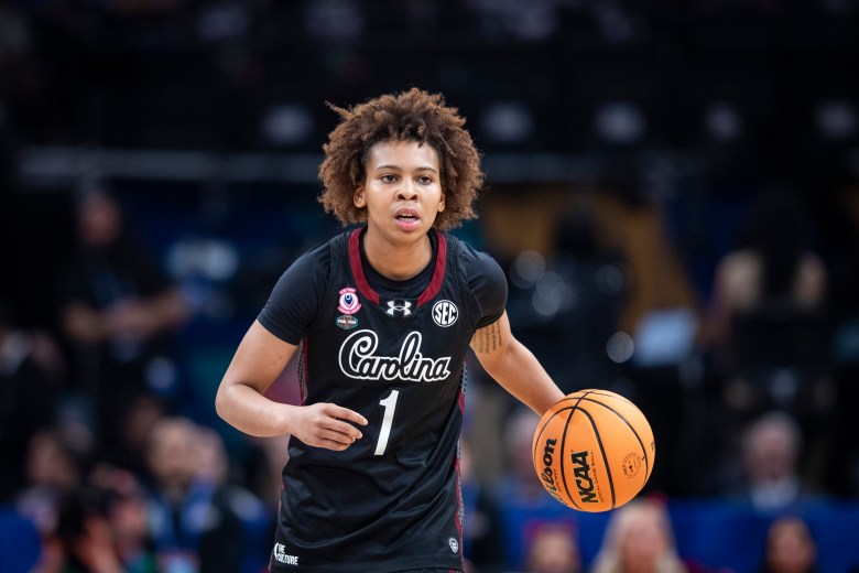 Maddy McDaniel is dribbling with the ball in her left hand and her mouth slighty open.