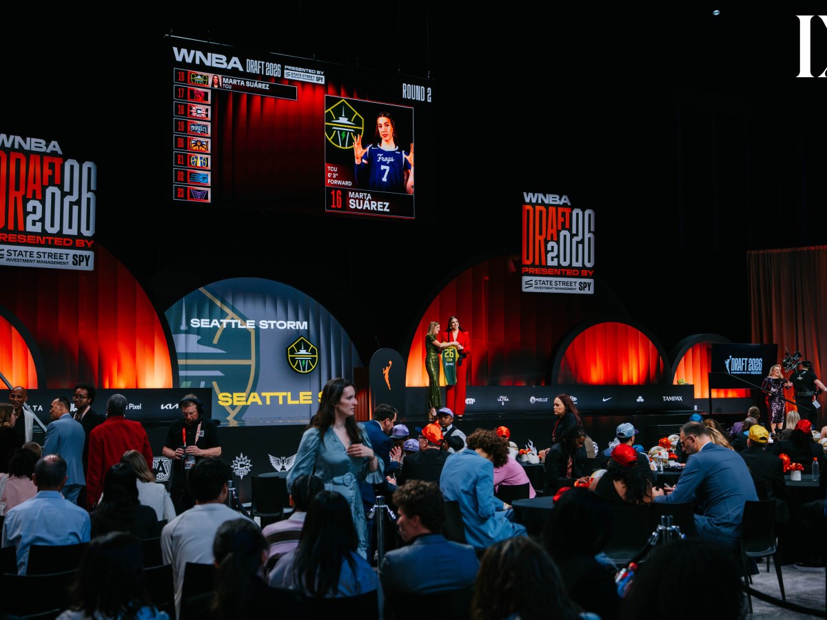 Marta Suárez holds up a Seattle Storm jersey with WNBA Commissioner Cathy Engelbert at the 2026 WNBA Draft, while the screens behind her announce her selection.