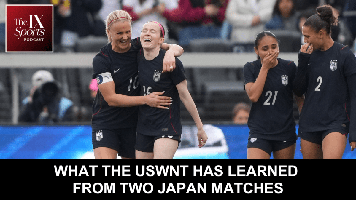 Teammates in black uniforms hug each other on the field after scoring a goal
