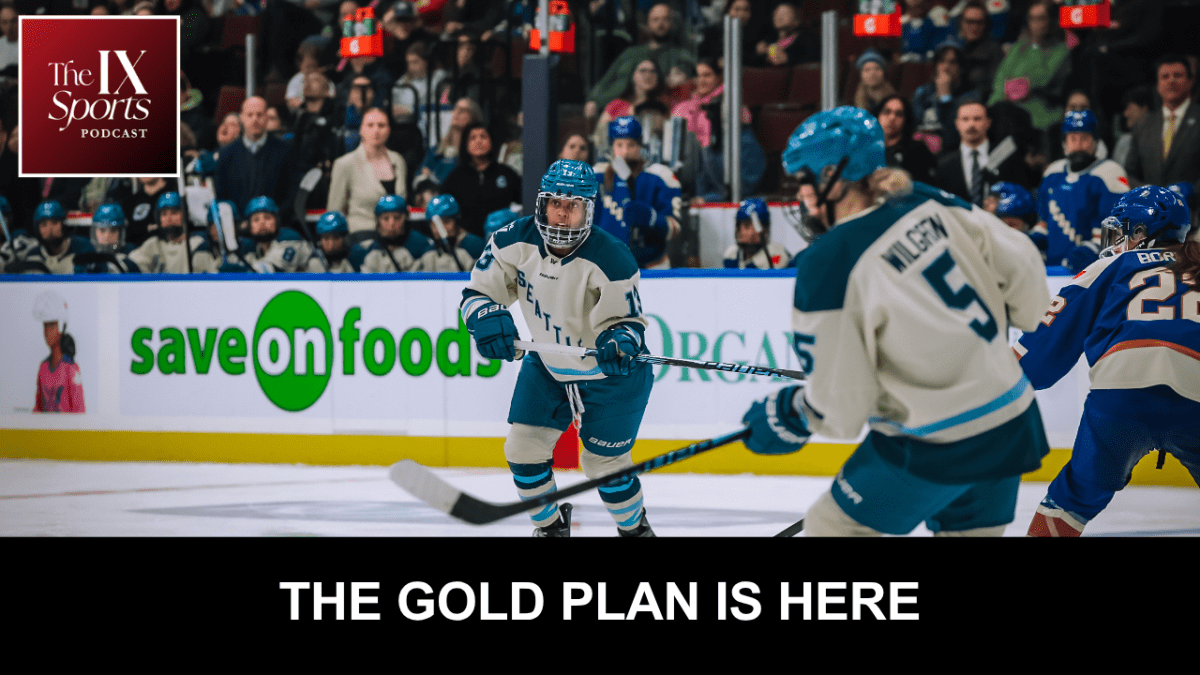 Two Seattle Torrent players pass the puck. There is a Vancouver player off to the right.