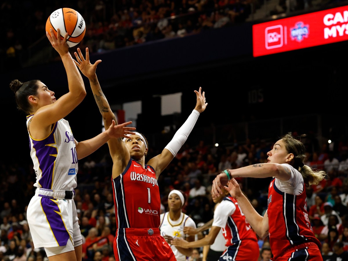 Washington Mystics guard Sug Sutton reaches with her right hand to try to contest a layup by Los Angeles Sparks guard Kelsey Plum. Mystics forward Emily Engstler is coming over to help but won't get there in time.