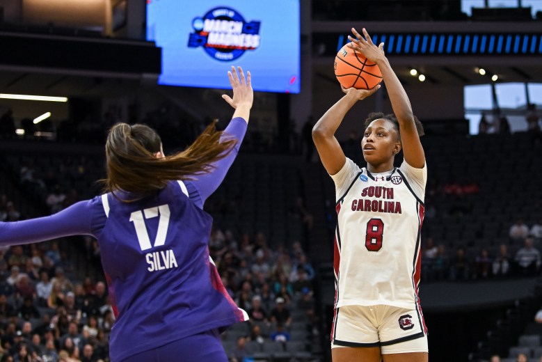 South Carolina forward Joyce Edwards (8) shoots over a defender who has her right hand outstretched. A crowd looks on in the background.