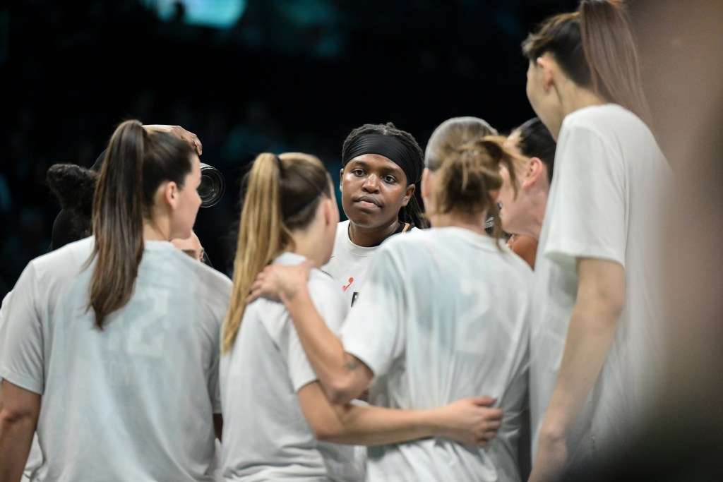 The Liberty gather in an on-court huddle.